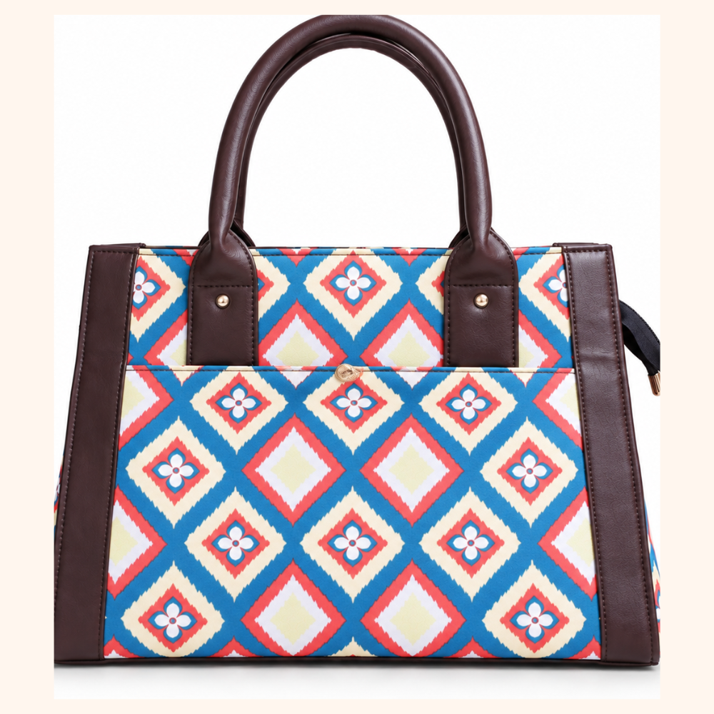 A structured tote bag with a colorful geometric diamond pattern in blue, red, cream, and white, accented by dark brown faux-leather trim and handles.